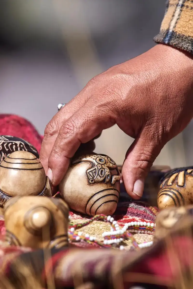 Hand placing carved ceremonial pieces